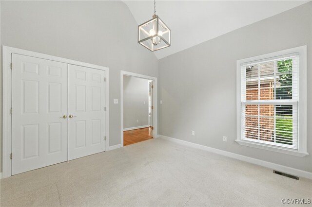 132 Warwick Hls, Williamsburg, VA 23188 - unfurnished bedroom featuring carpet, a chandelier, high vaulted ceiling, and a closet
