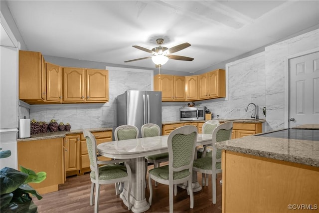 32390 S Main St, Boykins, VA 23827 - kitchen featuring light wood-style floors, ceiling fan, backsplash, appliances with stainless steel finishes, and light stone countertops