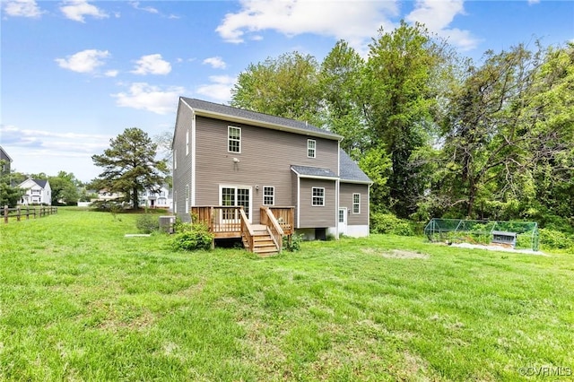 rear view of house with cooling unit, a yard, and a deck