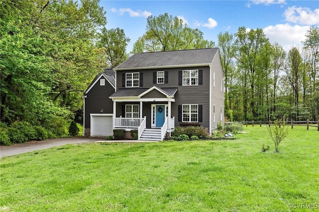 colonial inspired home featuring aphalt driveway, fence, covered porch, a front yard, and a garage