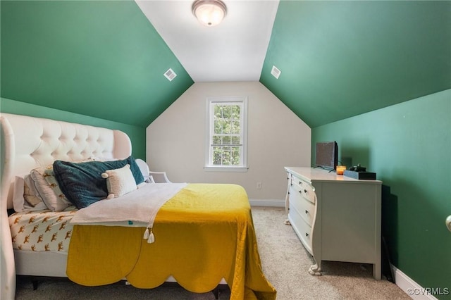 bedroom with baseboards, vaulted ceiling, visible vents, and light colored carpet