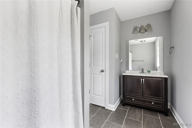 full bath with baseboards, vanity, and tile patterned floors