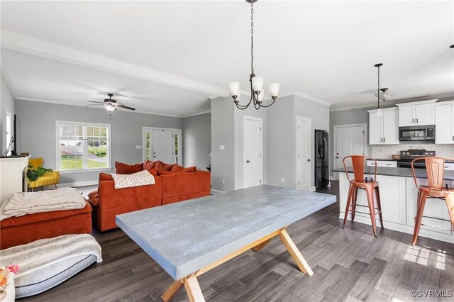 dining space with crown molding, dark wood-style floors, and ceiling fan with notable chandelier