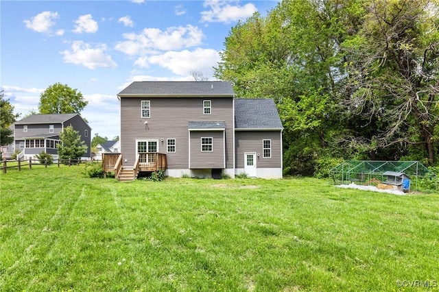 back of property featuring fence, a lawn, and a deck