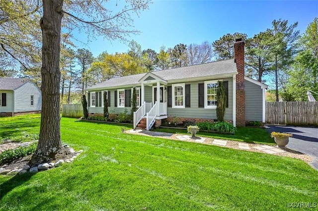 view of front of house featuring a chimney, fence, a front yard, and crawl space