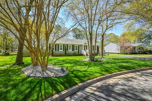ranch-style house featuring a chimney and a front yard