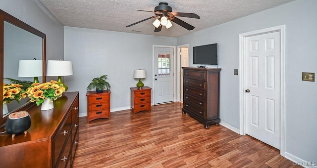 interior space featuring ceiling fan, a textured ceiling, and light wood-style flooring