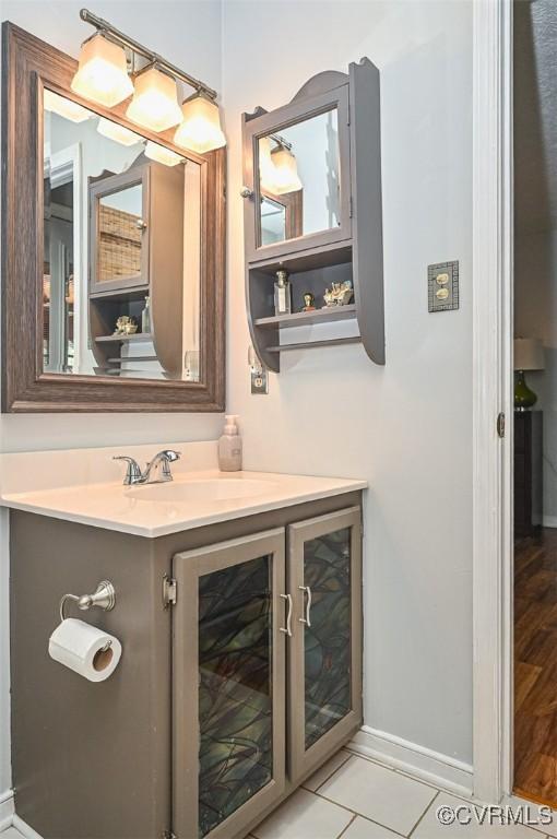 bathroom with tile patterned floors, vanity, and baseboards