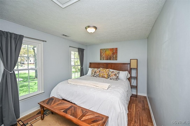 bedroom with multiple windows, visible vents, and baseboards