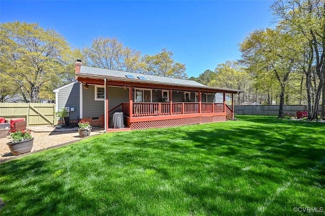 back of property featuring a chimney, a yard, crawl space, and a fenced backyard