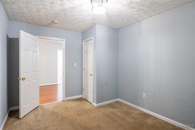 unfurnished bedroom featuring baseboards, carpet flooring, and a textured ceiling