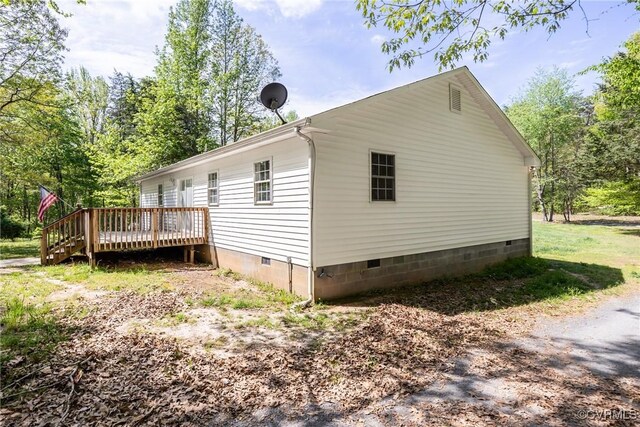 view of side of property featuring crawl space and a deck