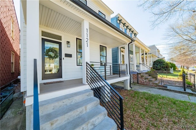 doorway to property featuring fence and a porch