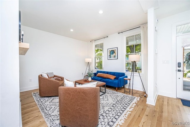 living area with light wood-type flooring, baseboards, and recessed lighting