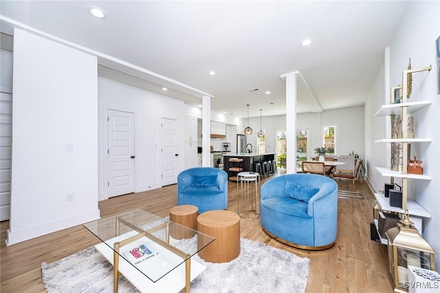 living room with baseboards, recessed lighting, and light wood-style floors