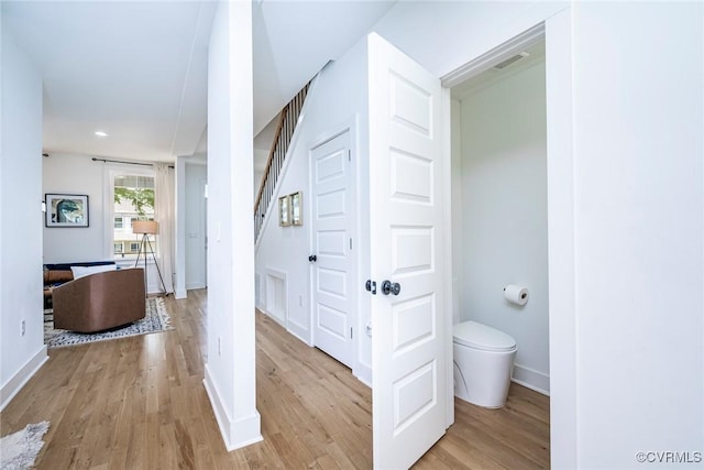 corridor featuring visible vents, baseboards, recessed lighting, and light wood-style floors