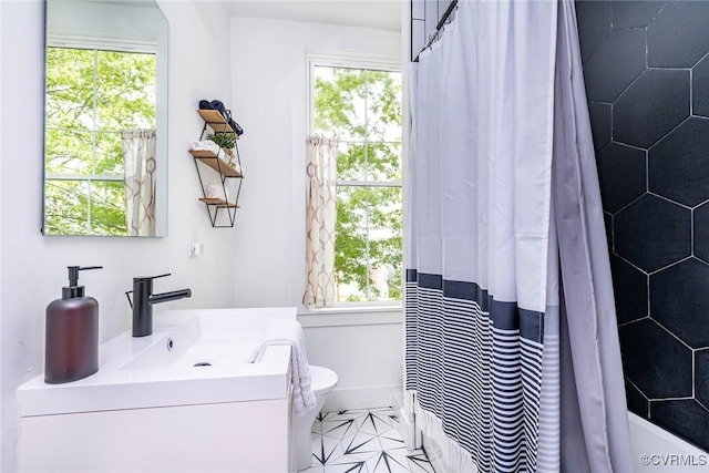 bathroom with a wealth of natural light, toilet, and vanity