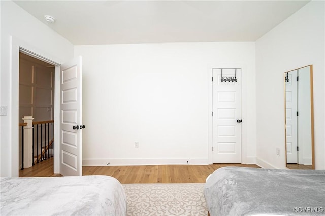 bedroom with baseboards and wood finished floors