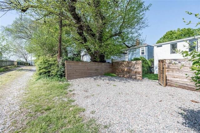 view of yard with fence and driveway
