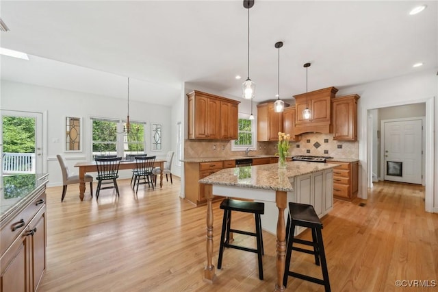 kitchen featuring decorative backsplash, a kitchen island, and light wood finished floors