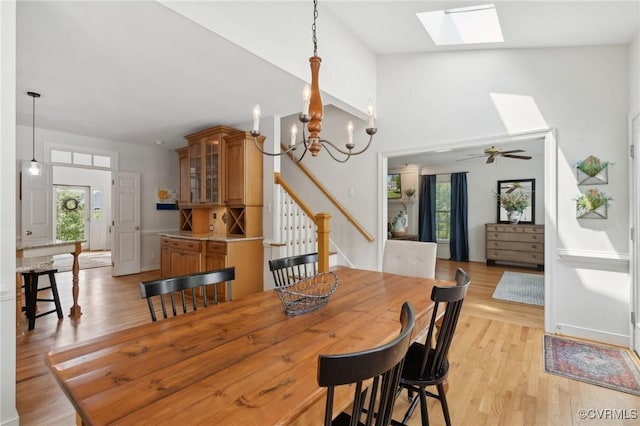 dining room featuring a skylight, light wood-style flooring, and a wealth of natural light
