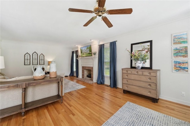 living room featuring crown molding, ceiling fan, and a fireplace