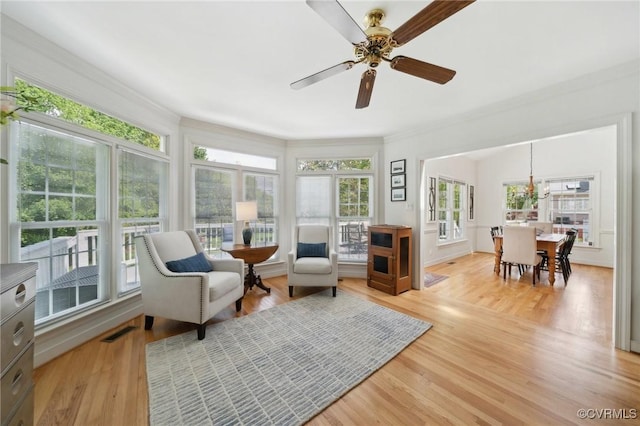 sunroom with visible vents, ornamental molding, wood finished floors, and a wooden deck