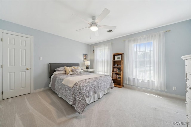 bedroom featuring baseboards, visible vents, light carpet, and ceiling fan