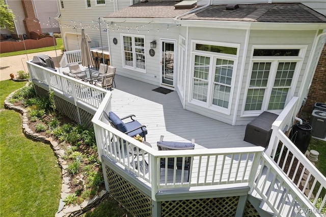wooden terrace with an attached garage and cooling unit
