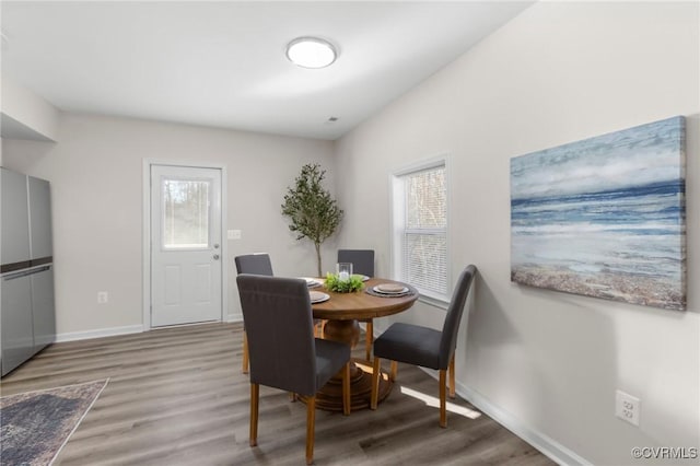 dining room with wood finished floors, baseboards, and a wealth of natural light