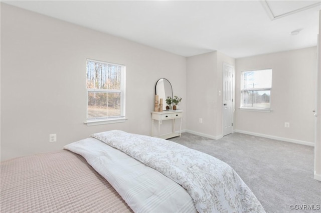 carpeted bedroom with baseboards, multiple windows, and attic access