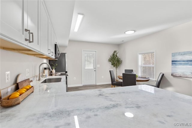 dining space with a healthy amount of sunlight, wood finished floors, and baseboards