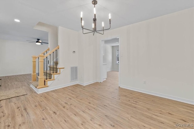 interior space featuring baseboards, visible vents, wood finished floors, and stairway