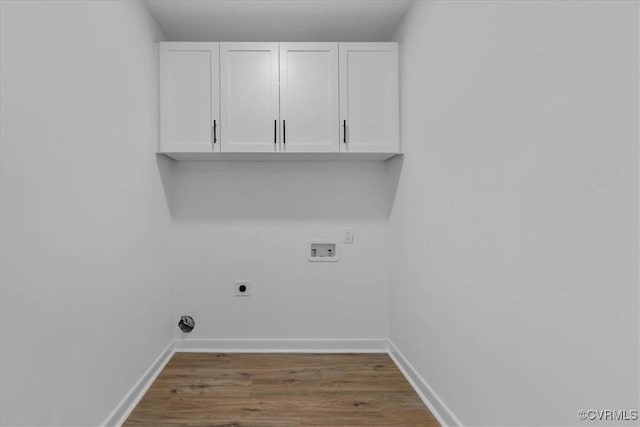 laundry area featuring cabinet space, washer hookup, baseboards, wood finished floors, and hookup for an electric dryer