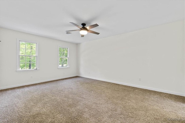 carpeted spare room with baseboards and a ceiling fan
