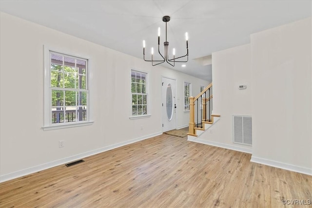 interior space with light wood-style floors, stairway, a chandelier, and visible vents