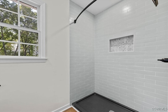 full bath with baseboards, a wealth of natural light, and a stall shower