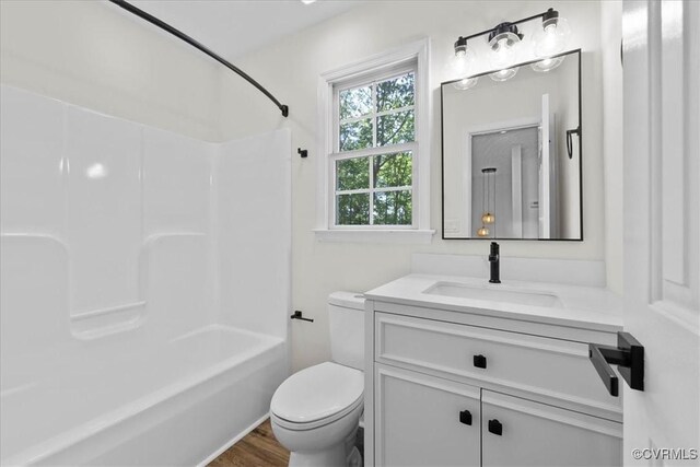 full bathroom with washtub / shower combination, vanity, toilet, and wood finished floors
