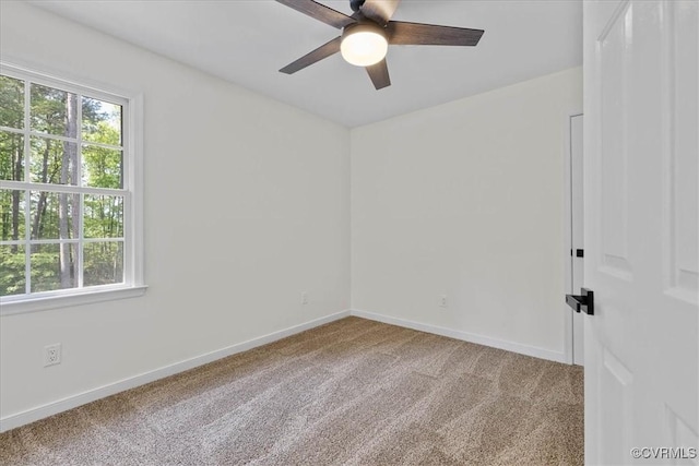 carpeted spare room featuring a ceiling fan, baseboards, and a healthy amount of sunlight