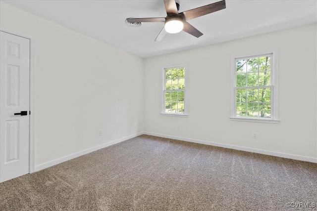 carpeted empty room with baseboards and a ceiling fan