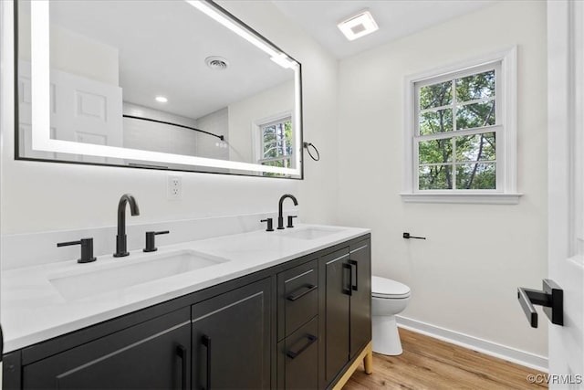 bathroom featuring baseboards, a healthy amount of sunlight, and a sink