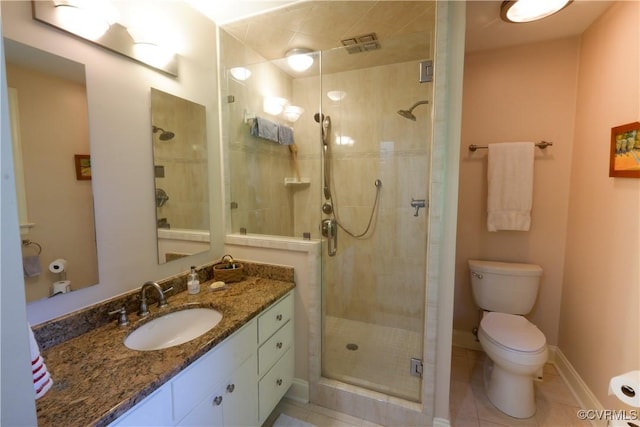 bathroom featuring a shower stall, vanity, tile patterned floors, baseboards, and toilet