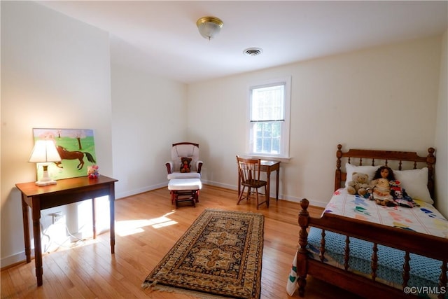 bedroom with baseboards, light wood-style flooring, and visible vents