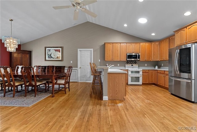 kitchen featuring light countertops, a peninsula, lofted ceiling, and stainless steel appliances