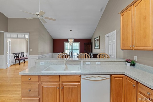 kitchen featuring light countertops, a sink, ceiling fan with notable chandelier, and dishwasher