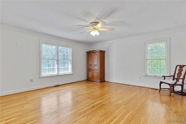 empty room with ceiling fan, visible vents, crown molding, baseboards, and light wood-style floors