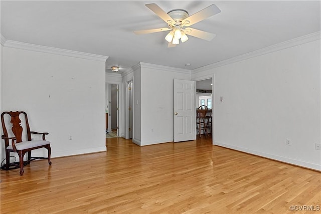 interior space with crown molding, baseboards, a ceiling fan, and light wood-style flooring
