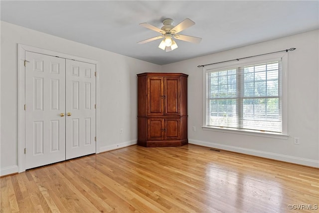 unfurnished bedroom with a closet, baseboards, visible vents, and light wood-type flooring