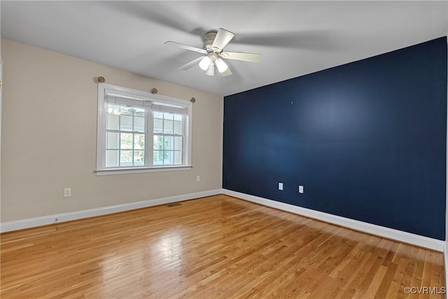 unfurnished room with baseboards, ceiling fan, and wood finished floors