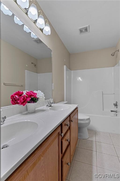 bathroom with visible vents, a sink, tile patterned flooring, and double vanity